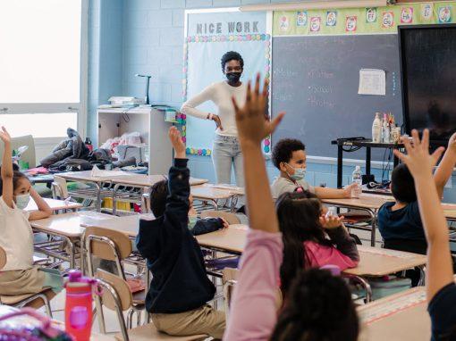 Lakeland - Teacher and Students Raising Hands